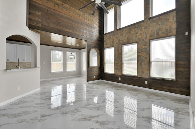 30507 Woodson Trace Dr, Spring, TX 77386 - empty room featuring a high ceiling, a ceiling fan, baseboards, marble finish flooring, and a sink