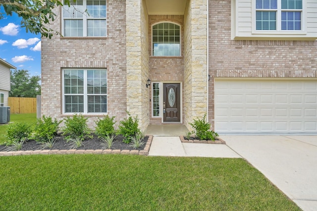 30507 Woodson Trace Dr, Spring, TX 77386 - view of exterior entry with concrete driveway, an attached garage, brick siding, and cooling unit