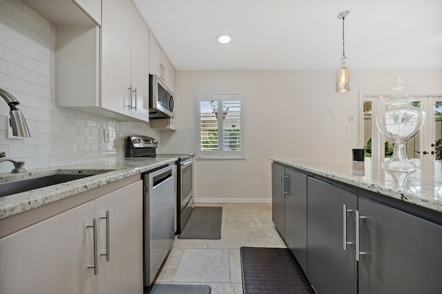 5859 Doliver Dr Unit 14, Houston, TX 77057 - kitchen with appliances with stainless steel finishes, a sink, decorative backsplash, pendant lighting, and baseboards