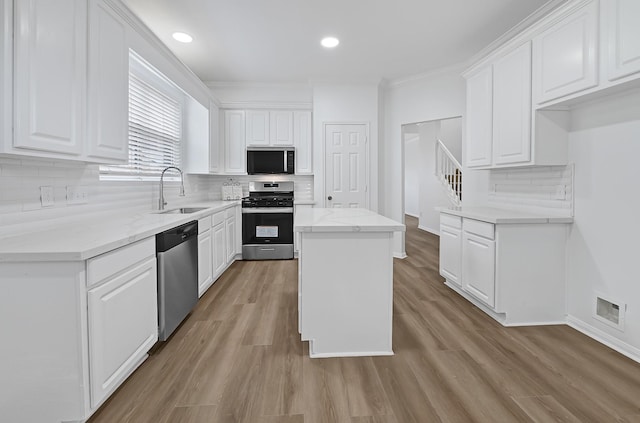 2918 Linda Dr, Pearland, TX 77584 - kitchen with stainless steel appliances, a sink, white cabinets, crown molding, and recessed lighting