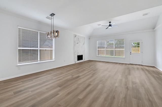 2918 Linda Dr, Pearland, TX 77584 - unfurnished living room with ceiling fan, wood finished floors, vaulted ceiling, a high end fireplace, and a chandelier