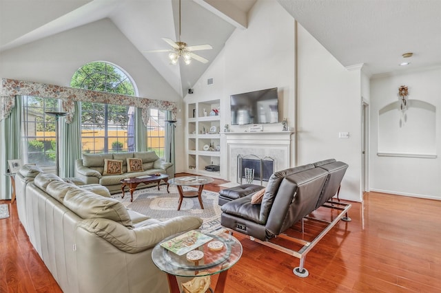 23207 Greenrush Dr, Katy, TX 77494 - living room featuring ceiling fan, wood finished floors, built in features, a fireplace, and high vaulted ceiling