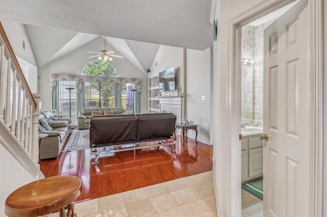 23207 Greenrush Dr, Katy, TX 77494 - living room featuring a ceiling fan, tile patterned flooring, lofted ceiling, and stairs