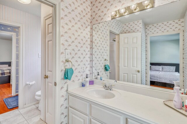 23207 Greenrush Dr, Katy, TX 77494 - ensuite bathroom featuring wallpapered walls, tile patterned flooring, vanity, and toilet