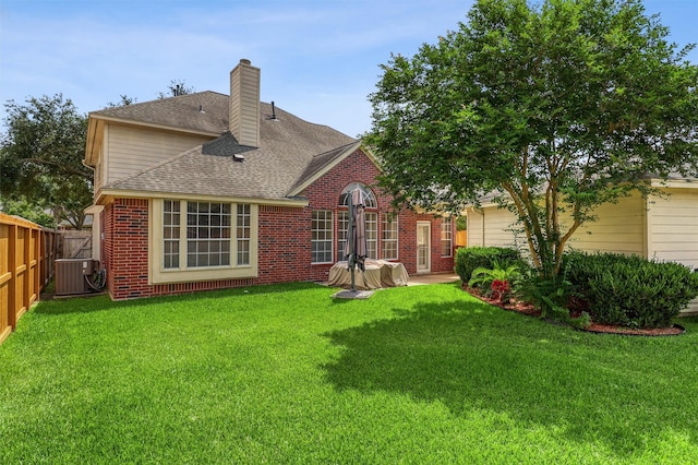 23207 Greenrush Dr, Katy, TX 77494 - back of property featuring central AC unit, a chimney, brick siding, and roof with shingles