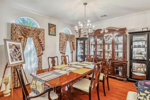 23207 Greenrush Dr, Katy, TX 77494 - dining area featuring a chandelier, light wood-style floors, healthy amount of natural light, and ornamental molding