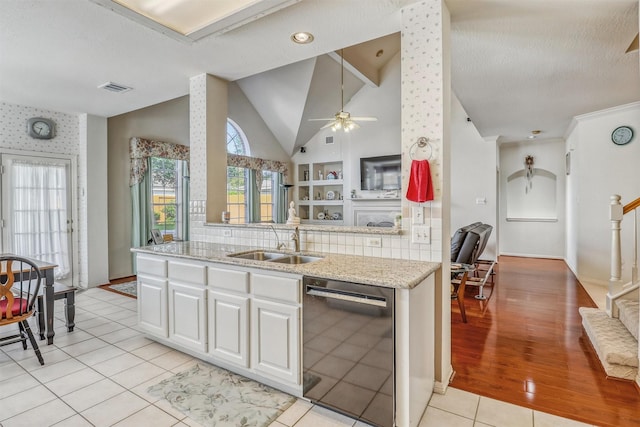 23207 Greenrush Dr, Katy, TX 77494 - kitchen with dishwasher, a sink, ceiling fan, white cabinets, and vaulted ceiling