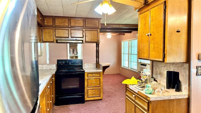 430 Hooks Rd, Livingston, TX 77351 - kitchen featuring black electric range, freestanding refrigerator, ceiling fan, carpet, and brown cabinets