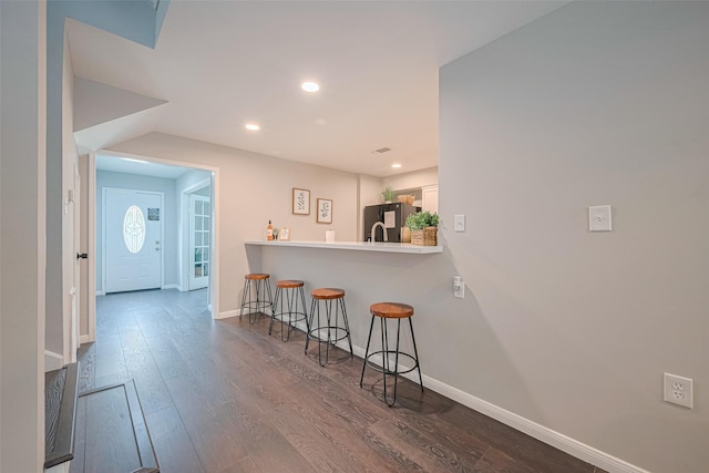 14688 Perthshire Rd Unit C, Houston, TX 77079 - kitchen with a breakfast bar area, freestanding refrigerator, baseboards, dark wood finished floors, and white cabinets