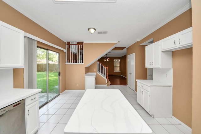 4907 Heritage Plains Dr, Friendswood, TX 77546 - kitchen with stainless steel dishwasher, light tile patterned floors, white cabinets, crown molding, and baseboards