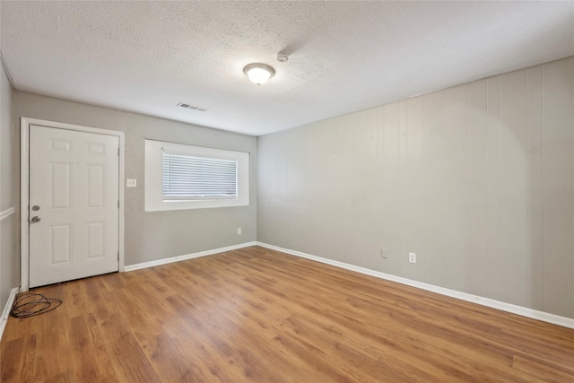 9270 Mclean St, Beaumont, TX 77707 - empty room featuring light wood-style floors, a textured ceiling, and baseboards