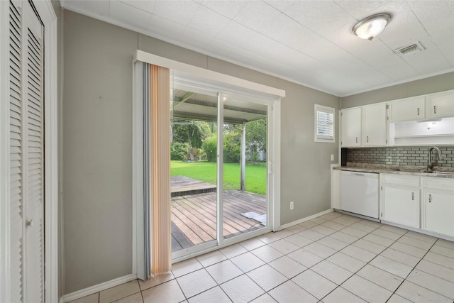 9270 Mclean St, Beaumont, TX 77707 - kitchen with dishwasher, a sink, baseboards, decorative backsplash, and white cabinets