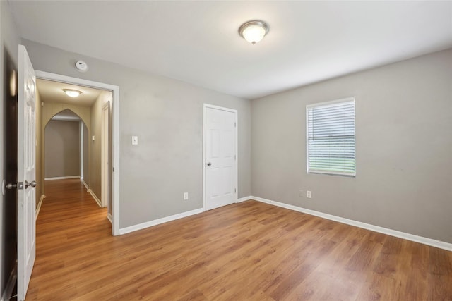 9270 Mclean St, Beaumont, TX 77707 - unfurnished bedroom featuring light wood-style flooring, baseboards, and arched walkways