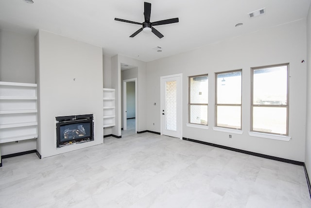208 Silverleaf Rd, Sweeny, TX 77480 - unfurnished living room featuring built in shelves, a glass covered fireplace, ceiling fan, and baseboards