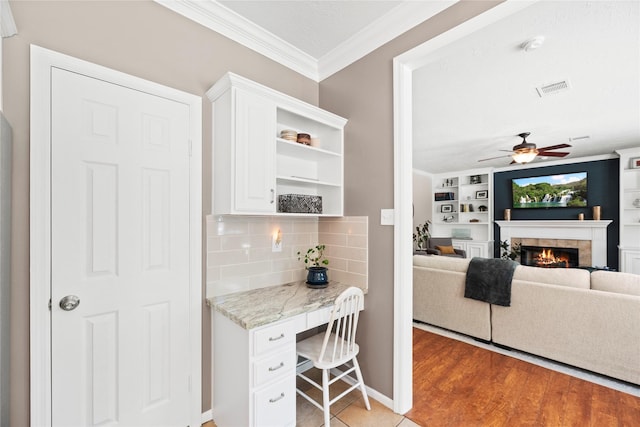 7818 Palm Brook Ct, Houston, TX 77095 - kitchen with ornamental molding, a fireplace, white cabinetry, open shelves, and a ceiling fan