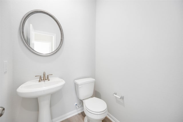 1039 Lilly Ln, Bellville, TX 77418 - half bathroom with wood finished floors, baseboards, and toilet