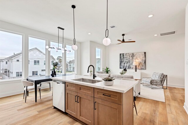 4703 Oats St Unit B, Houston, TX 77020 - kitchen featuring a sink, dishwasher, open floor plan, light wood finished floors, and an island with sink