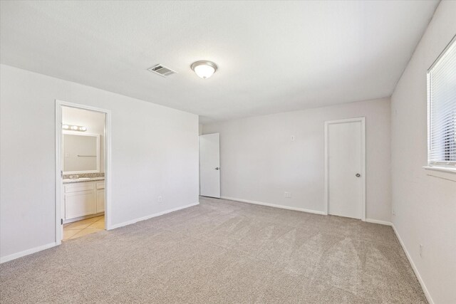 5519 Fallengate Dr, Spring, TX 77373 - unfurnished bedroom with light carpet, ensuite bath, and baseboards