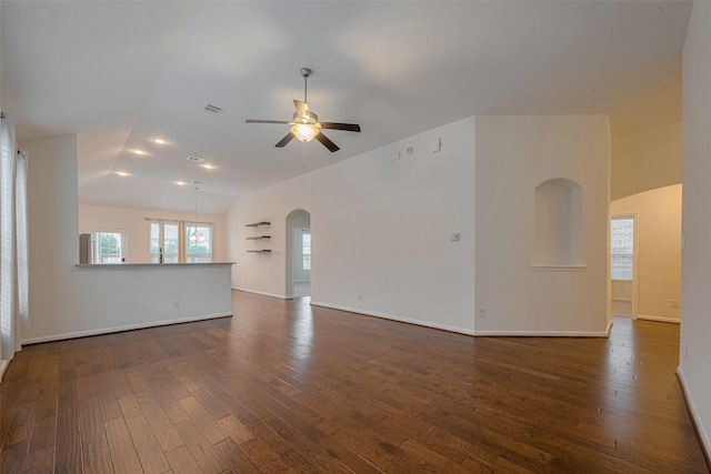 9715 Deborah Colony Ln, Humble, TX 77396 - unfurnished living room with lofted ceiling, a ceiling fan, dark wood-type flooring, baseboards, and arched walkways