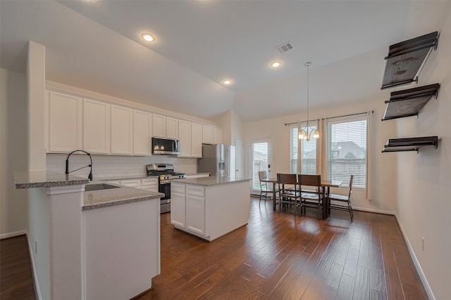 9715 Deborah Colony Ln, Humble, TX 77396 - kitchen with appliances with stainless steel finishes, a sink, backsplash, white cabinetry, and vaulted ceiling