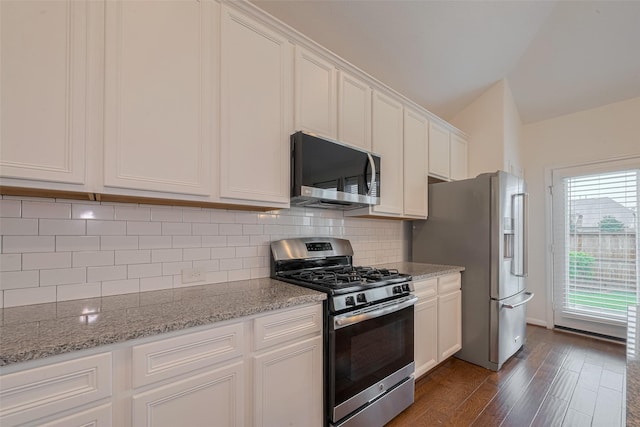9715 Deborah Colony Ln, Humble, TX 77396 - kitchen with stainless steel appliances, white cabinets, dark wood finished floors, light stone countertops, and tasteful backsplash