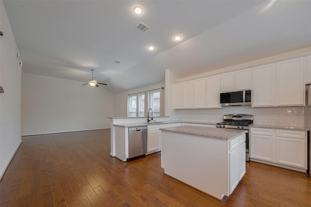 9715 Deborah Colony Ln, Humble, TX 77396 - kitchen with stainless steel appliances, a sink, vaulted ceiling, a peninsula, and backsplash