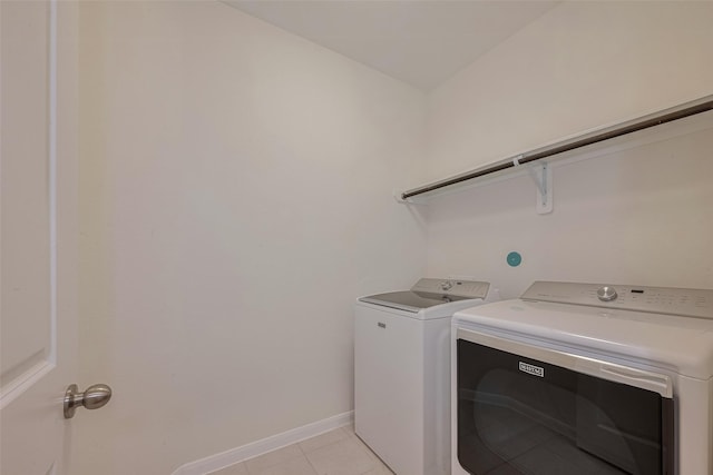 9715 Deborah Colony Ln, Humble, TX 77396 - laundry area featuring washing machine and clothes dryer, light tile patterned floors, and baseboards
