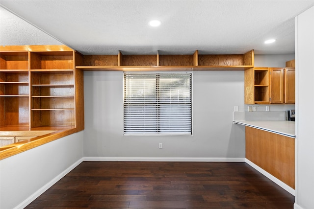 283 Sam Loop, Houston Loop, Point Blank, TX 77364 - unfurnished dining area featuring dark wood-style flooring, baseboards, a textured ceiling, and recessed lighting