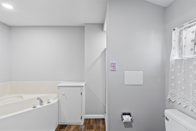 283 Sam Loop, Houston Loop, Point Blank, TX 77364 - bathroom featuring wood finished floors, a garden tub, toilet, and baseboards