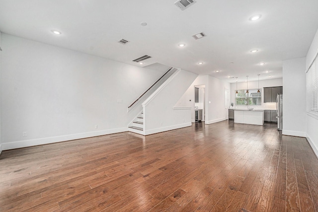 1266 N Post Oak Rd Unit B, Houston, TX 77055 - unfurnished living room featuring dark wood finished floors, stairway, and recessed lighting