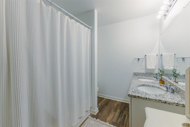 940 Cedar Point Dr, Livingston, TX 77351 - full bathroom with wood finished floors, double vanity, toilet, baseboards, and a shower with shower curtain