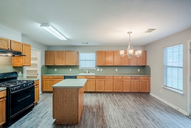 21106 Scenic Bluff Ln, Humble, TX 77338 - kitchen with black range with gas stovetop, a sink, under cabinet range hood, and light wood-style flooring