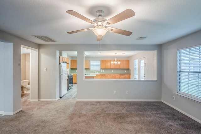 21106 Scenic Bluff Ln, Humble, TX 77338 - unfurnished living room featuring light colored carpet, a chandelier, a ceiling fan, and baseboards