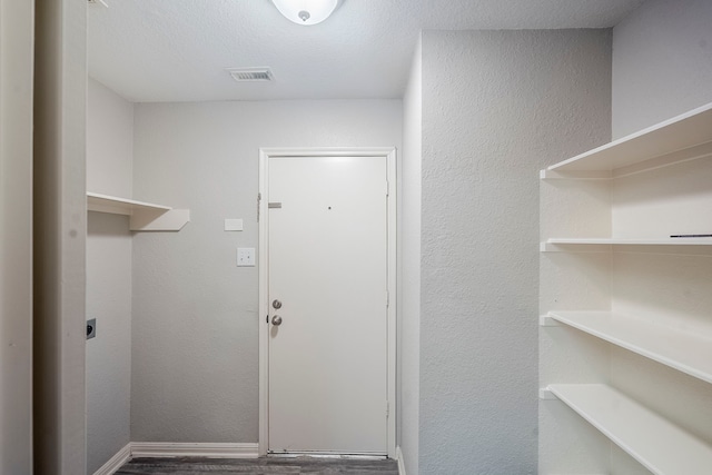 21106 Scenic Bluff Ln, Humble, TX 77338 - laundry area featuring electric dryer hookup, wood finished floors, baseboards, and a textured wall