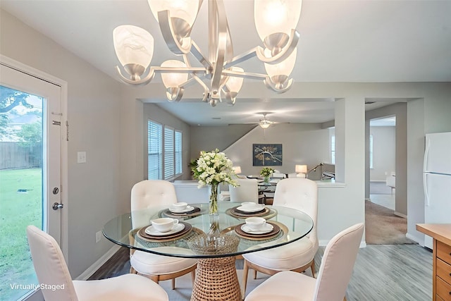 21106 Scenic Bluff Ln, Humble, TX 77338 - dining room with wood finished floors, baseboards, and a chandelier