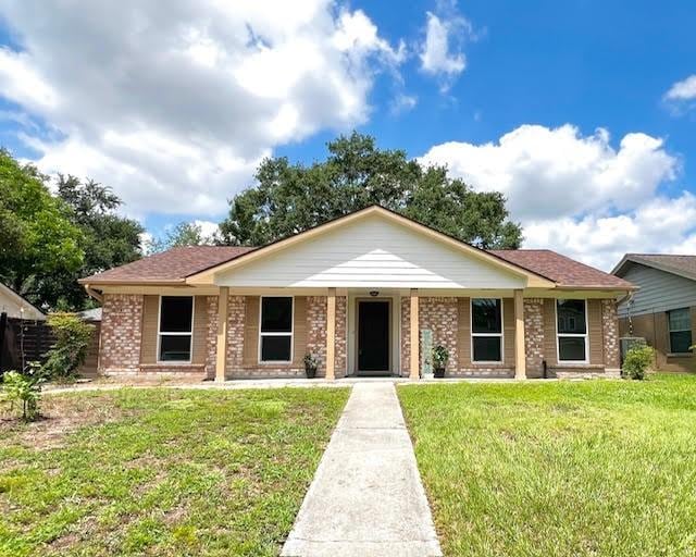 9015 Stone Brook Ln, Houston, TX 77040 - ranch-style house with a front yard, brick siding, and a porch