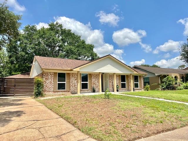 9015 Stone Brook Ln, Houston, TX 77040 - view of front of home featuring brick siding, a front lawn, and a porch