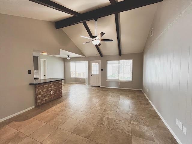 9015 Stone Brook Ln, Houston, TX 77040 - unfurnished living room featuring beam ceiling, ceiling fan, baseboards, and high vaulted ceiling