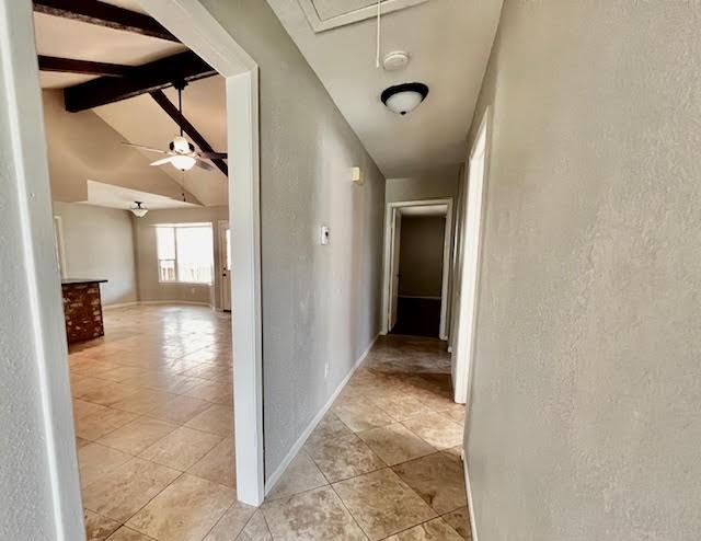 9015 Stone Brook Ln, Houston, TX 77040 - hallway with a textured wall, attic access, light tile patterned floors, and baseboards