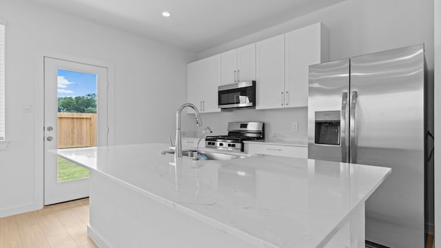 1823 Revolution Way, Missouri City, TX 77489 - kitchen with stainless steel appliances, an island with sink, white cabinets, healthy amount of natural light, and recessed lighting