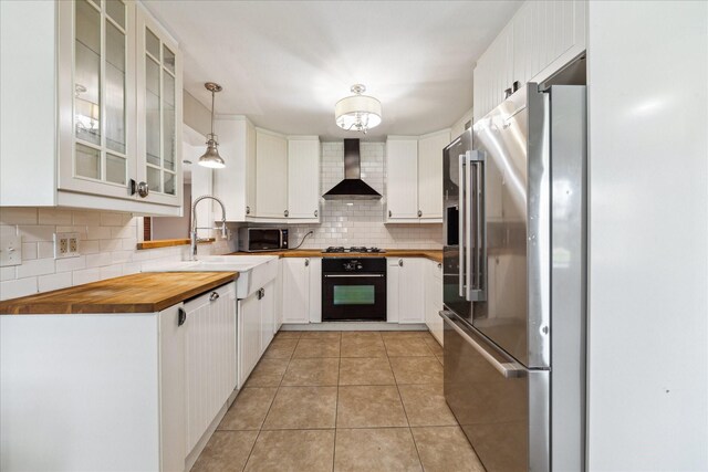 4301 Ascot Ln, Houston, TX 77092 - kitchen featuring wall chimney exhaust hood, black appliances, wooden counters, backsplash, and white cabinetry