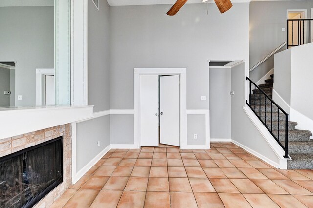 4319 Conward Dr, Houston, TX 77066 - unfurnished living room featuring a ceiling fan, stairs, a high ceiling, and a tile fireplace