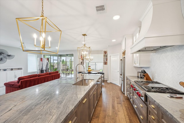 29303 Kellys Falls Ct, Katy, TX 77494 - kitchen featuring a sink, custom range hood, a chandelier, appliances with stainless steel finishes, and backsplash