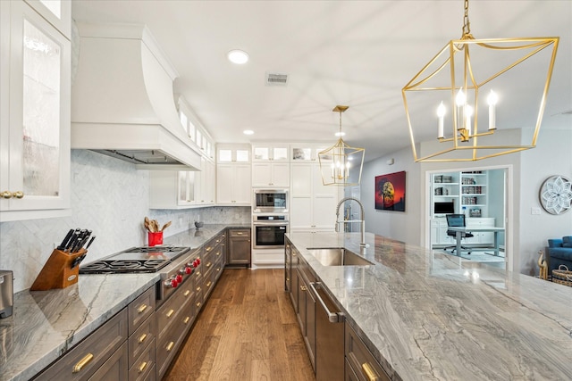 29303 Kellys Falls Ct, Katy, TX 77494 - kitchen with a sink, premium range hood, stainless steel appliances, a chandelier, and dark wood-style flooring