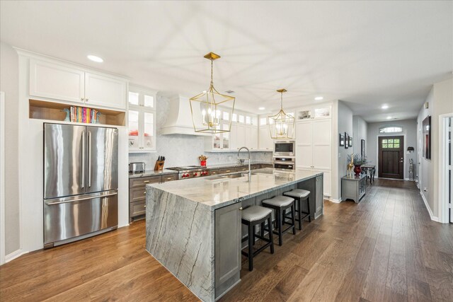 29303 Kellys Falls Ct, Katy, TX 77494 - kitchen with appliances with stainless steel finishes, premium range hood, dark wood finished floors, recessed lighting, and a chandelier