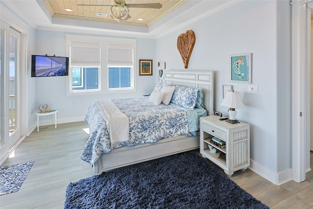 23125 Gulf Dr, Galveston, TX 77554 - bedroom featuring a raised ceiling, ornamental molding, light wood-type flooring, and a ceiling fan