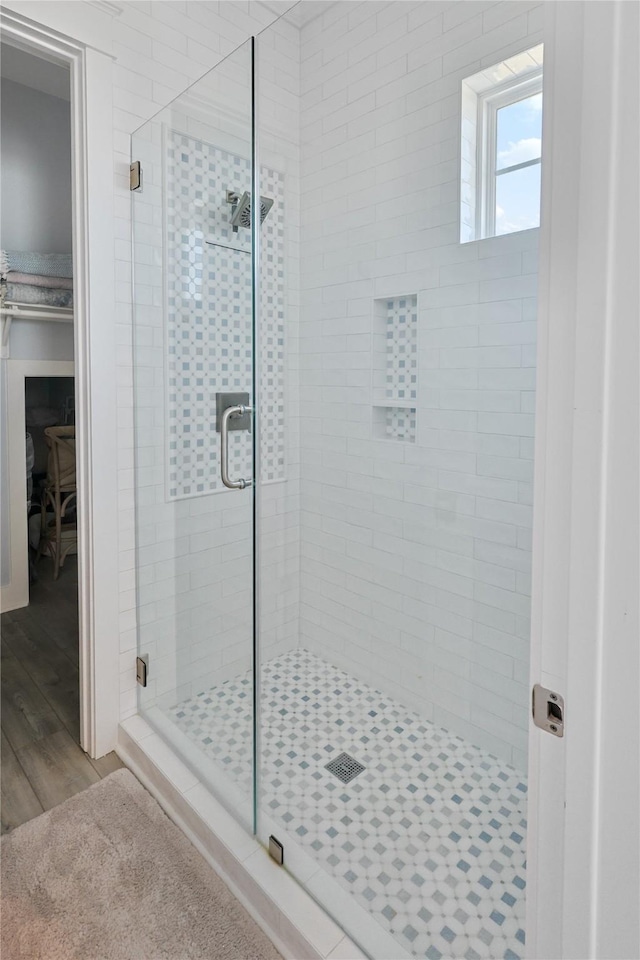 23125 Gulf Dr, Galveston, TX 77554 - bathroom featuring a shower stall, wood finished floors, and a walk in closet