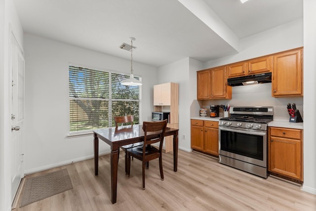 6107 Villa Hills Dr, Houston, TX 77066 - kitchen with stainless steel range with gas stovetop, under cabinet range hood, light wood-style floors, light countertops, and decorative light fixtures