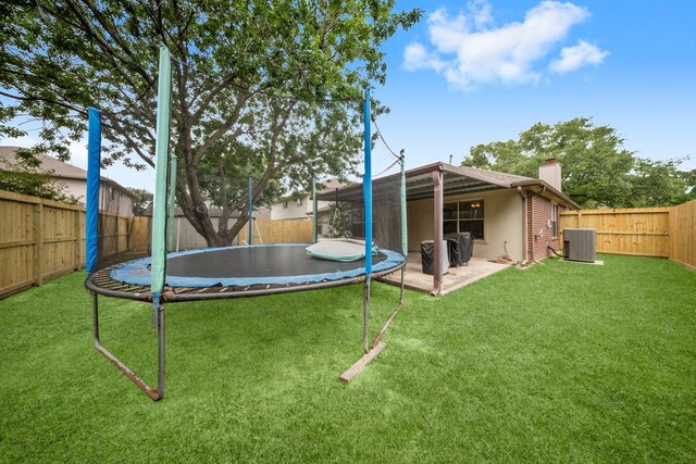 6107 Villa Hills Dr, Houston, TX 77066 - view of yard featuring a trampoline, central air condition unit, and a patio area