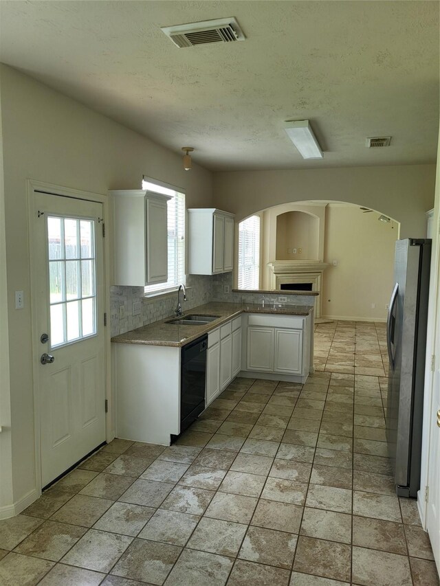 19734 Logan Briar Dr, Tomball, TX 77375 - kitchen featuring stainless steel fridge, dishwasher, a sink, decorative backsplash, and white cabinetry